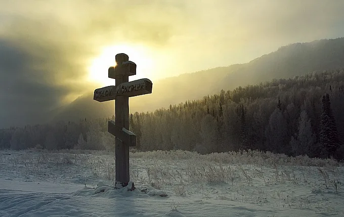 Хрест на сніжному полі під сонцем