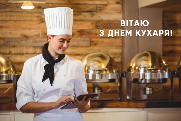 Кухарка з планшетом на фоні страв у чавінгах.