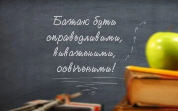 Побажання першокласнику на дошці з яблуком та книгою.