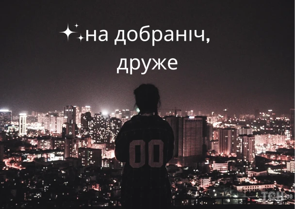 Чоловік стоїть на даху з видом на нічне місто.